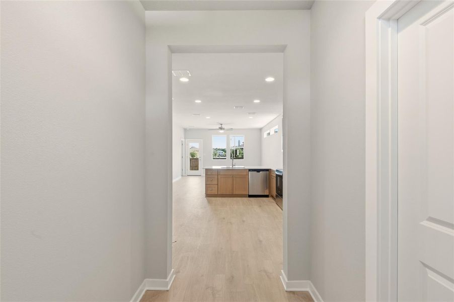 Corridor with light wood-style floors and recessed lighting