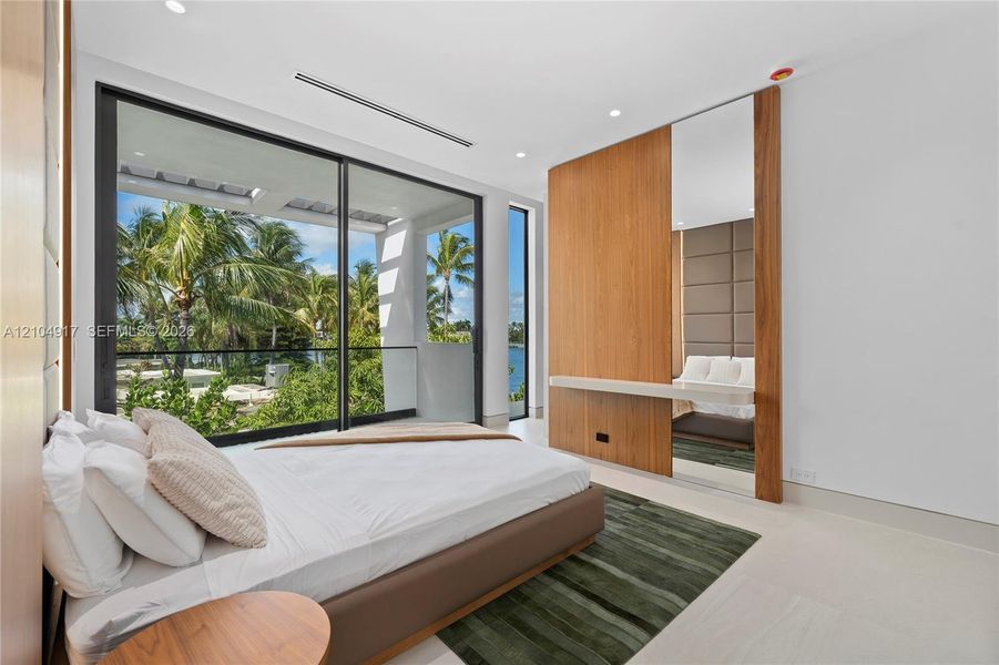 Expansive sliding glass doors, built-in wooden cabinetry, recessed ceiling lighting, and light-toned flooring
