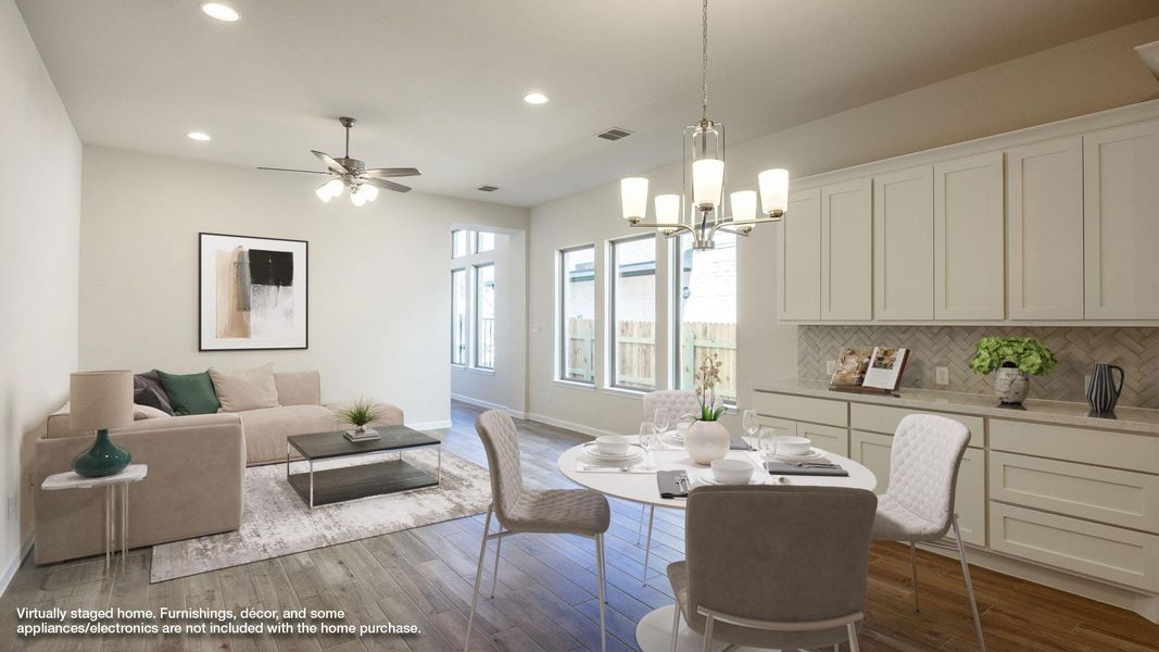 Dining area featuring wood finished floors, recessed lighting, ceiling fan with notable chandelier, and baseboards