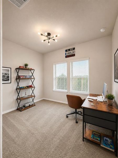 Carpeted room featuring dual windows, a contemporary sputnik-style ceiling light fixture, and neutral wall tones