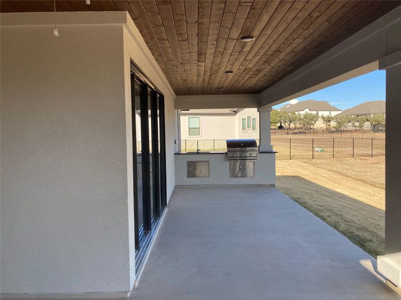 Enjoy the picturesque, Texas Hill Country views from the covered patio of this home that comes complete with a built-in outdoor kitchen and ceiling fan.