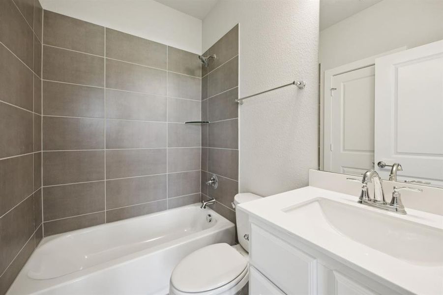 Full bath with vanity, bathing tub / shower combination, and a textured wall