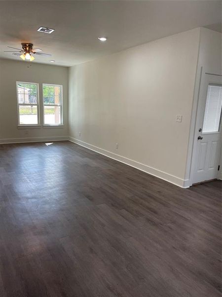 Empty room with dark hardwood / wood-style flooring and ceiling fan