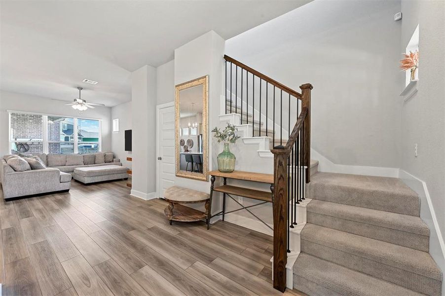 Staircase featuring wood finished floors and ceiling fan Staircase featuring wood finished floors and ceiling fan