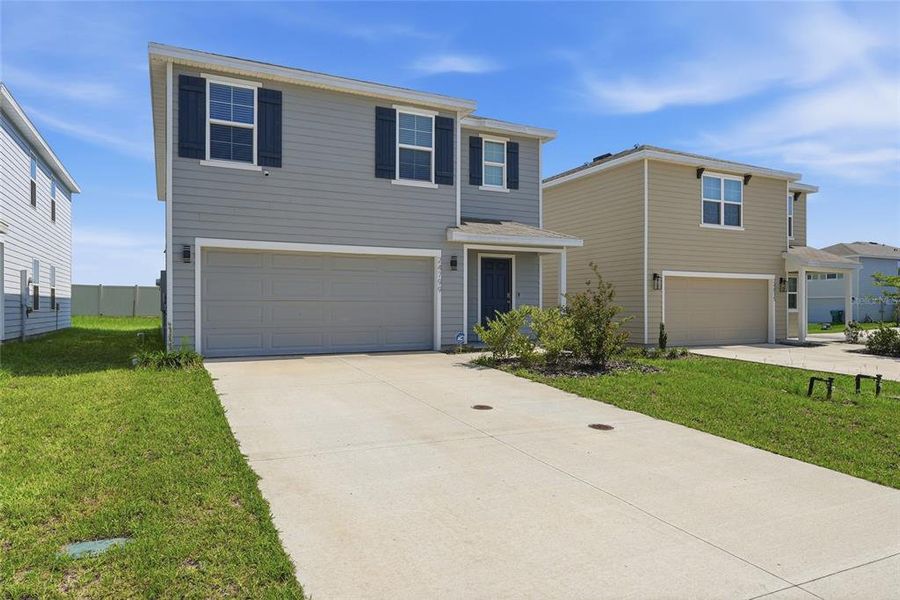 Front exterior of a new home in Avalon Woods, Newberry, FL, highlighting curb appeal (Image 25).