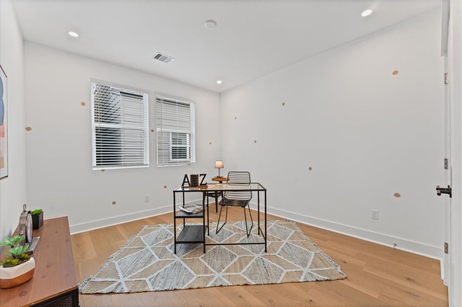 This versatile secondary bedroom on the second floor is currently staged as a stylish home office, featuring a sleek desk setup, ample natural light, and minimalist décor that enhances focus and creativity. Its neutral palette and uncluttered layout make it easy to reimagine, whether as a cozy guest room, a serene yoga space, or a vibrant playroom. The room’s flexible design invites endless possibilities, adapting effortlessly to suit changing needs and lifestyles.