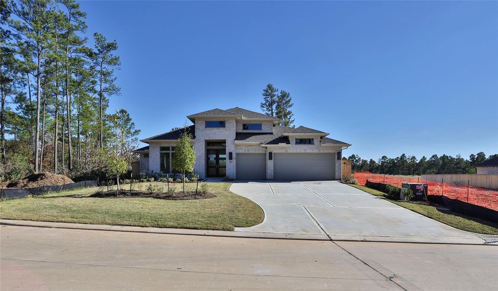 Front exterior of a new home in Kresston 65', Magnolia, TX, highlighting curb appeal (Image 2). Front exterior of a new home in Kresston 65', Magnolia, TX, highlighting curb appeal (Image 2).