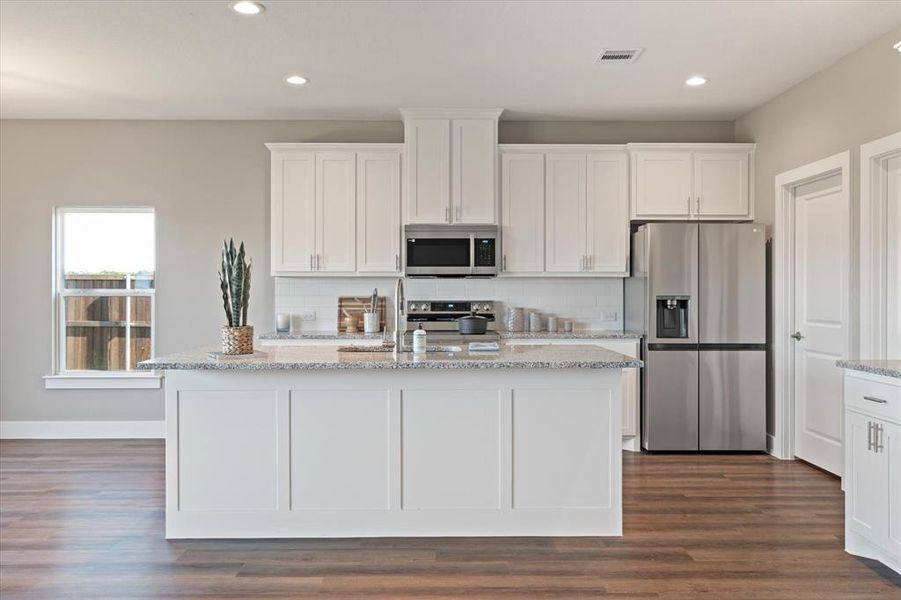 Kitchen with white cabinets, stainless steel appliances, and a kitchen island with sink Kitchen with white cabinets, stainless steel appliances, and a kitchen island with sink