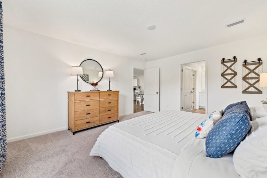 A bedroom with a bed and a dresser.