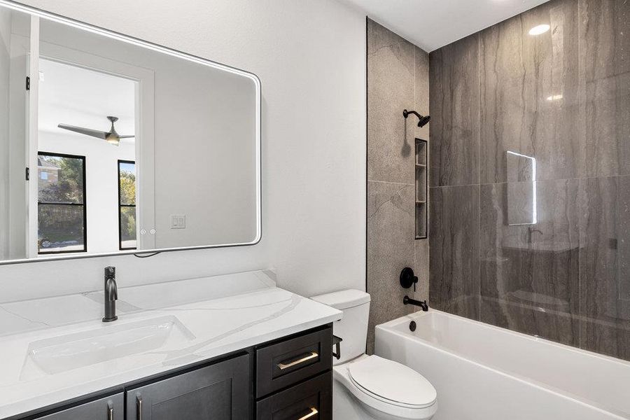 The ensuite bath for the second floor bedroom comes with designer finishes and a modern shower/tub combo with tiled backsplash.