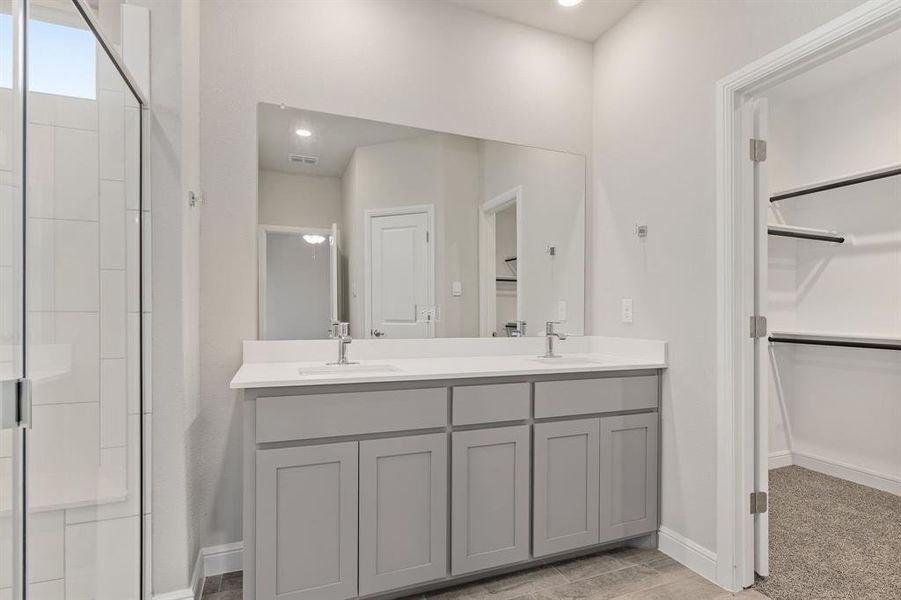 Bathroom with vanity and a shower with door