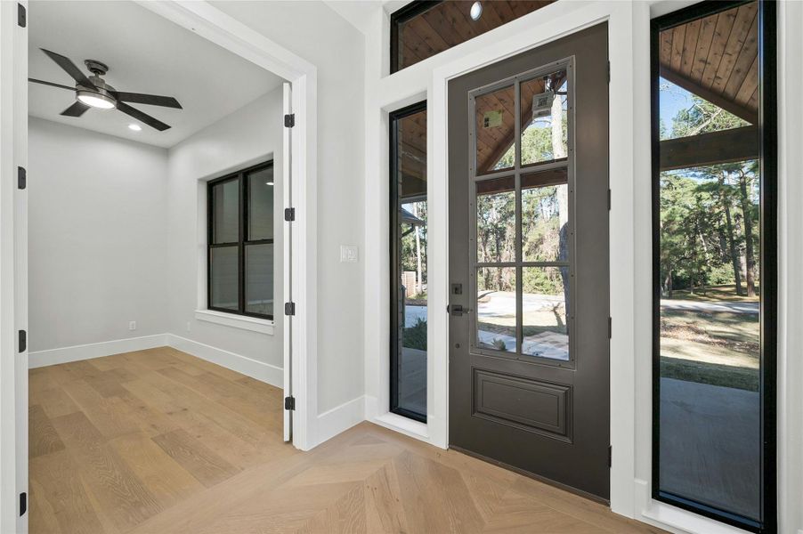 Doorway featuring ceiling fan and light parquet flooring