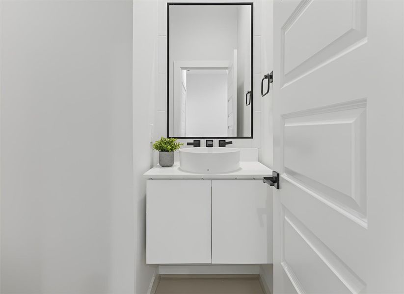 Powder bathroom features a clean, modern look with a white tile backsplash extending to the ceiling, creating a bright, airy, and polished feel. *Virtually staged*