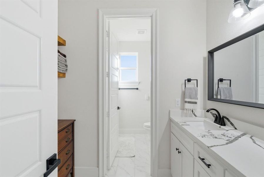 Bathroom featuring light marble finish floors and vanity