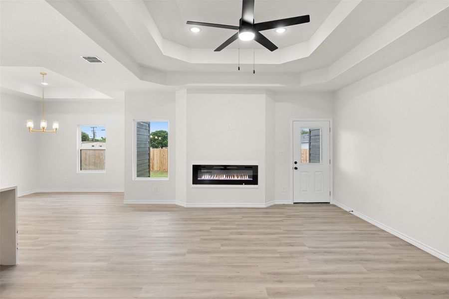 A spacious living area with soaring tray ceilings and a contemporary fireplace provides a welcoming ambiance. A spacious living area with soaring tray ceilings and a contemporary fireplace provides a welcoming ambiance.