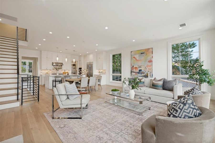 Open-concept layout featuring a view of the second-floor living spaces and staircase access to the third-floor bedrooms. Open-concept layout featuring a view of the second-floor living spaces and staircase access to the third-floor bedrooms.