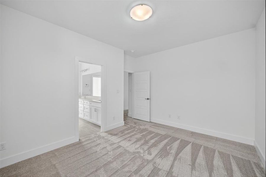 Empty room featuring light carpet and baseboards