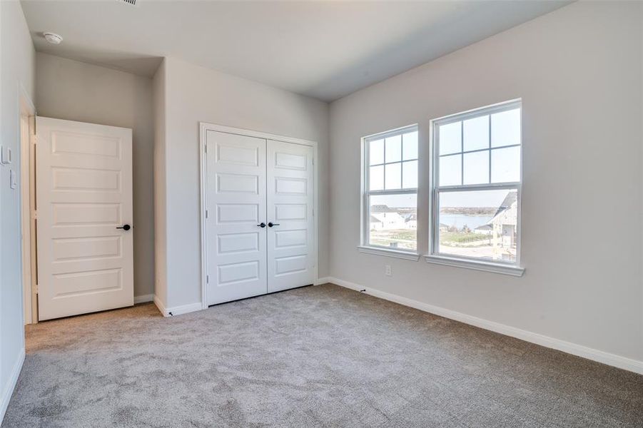 Unfurnished bedroom featuring light carpet and a closet