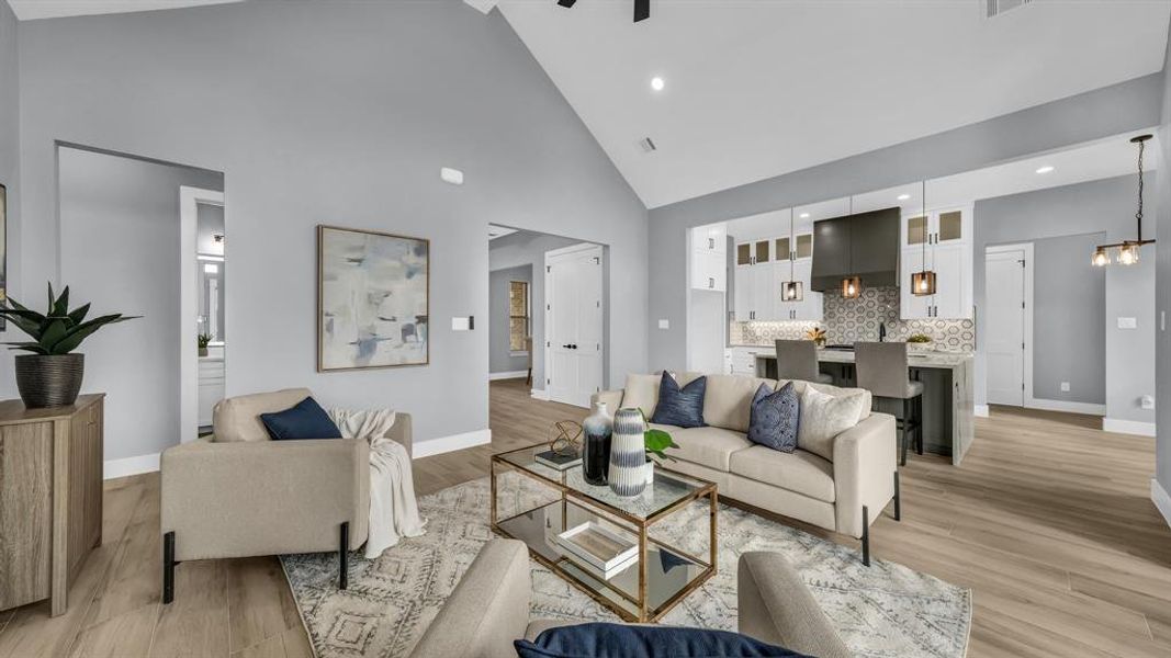 Living area featuring high vaulted ceiling, recessed lighting, and light wood-style floors