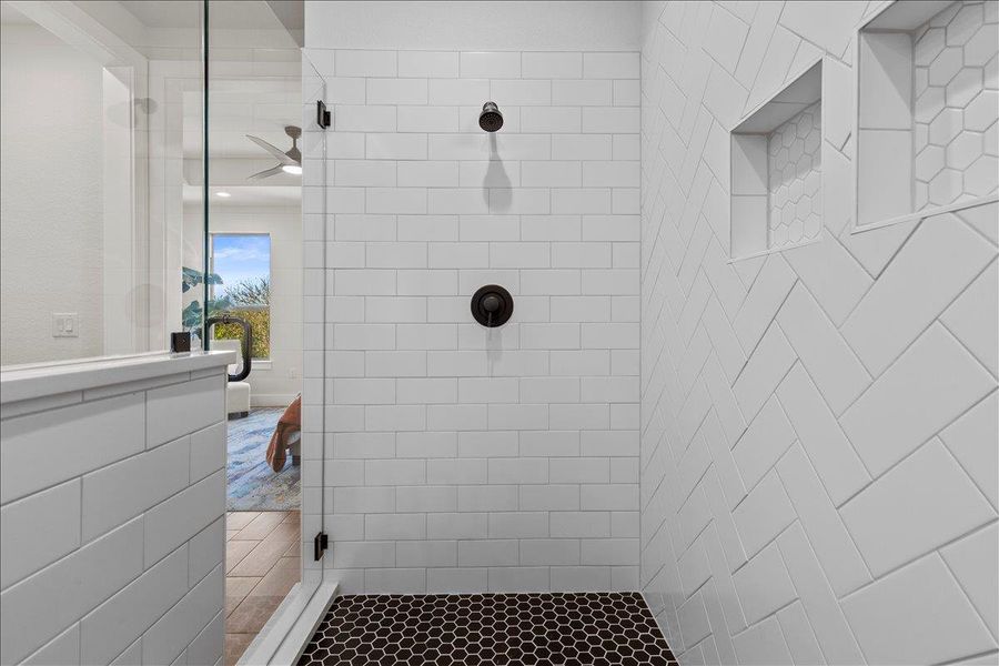 Full bath featuring tiled shower and ceiling fan