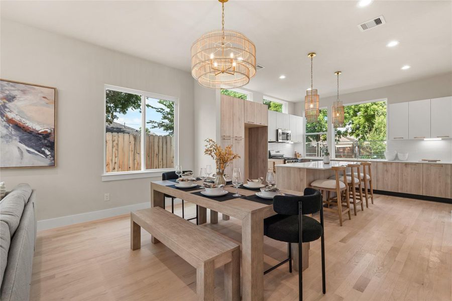 Inviting dining area anchored by a chandelier & surrounded by large windows that bring in beautiful natural light, perfect for everyday meals or hosting family and friends.