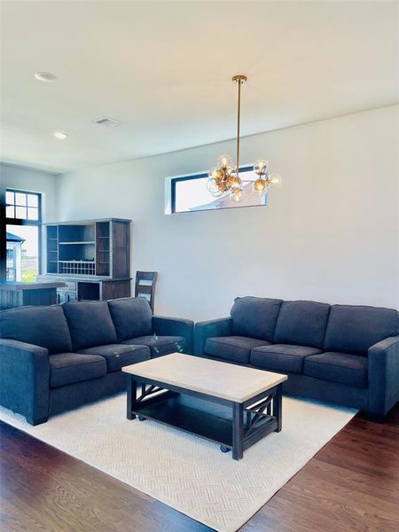 Living area with wood finished floors, a chandelier, and recessed lighting Living area with wood finished floors, a chandelier, and recessed lighting