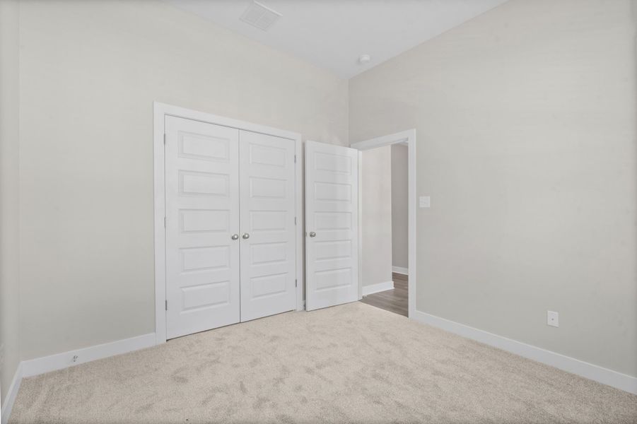 Plush carpeting, clean white walls, and a recessed ceiling light