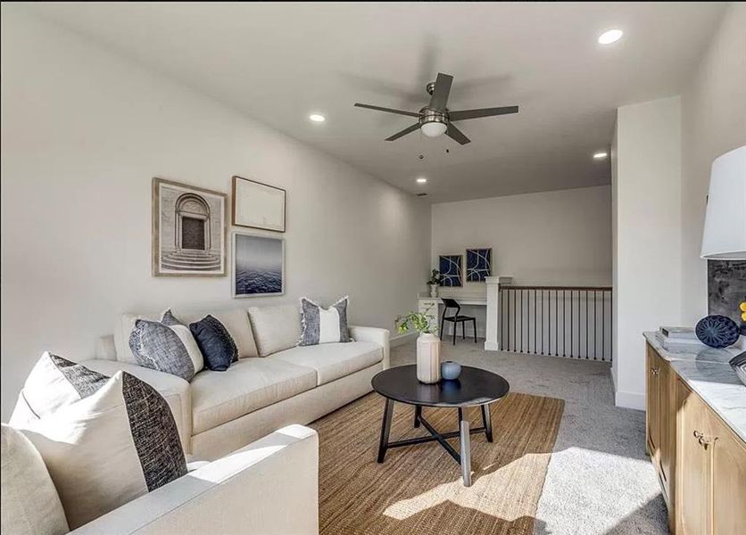 Living room with light colored carpet and ceiling fan