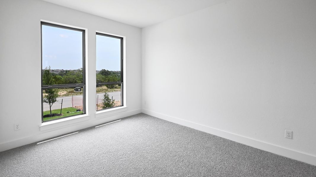 Empty room with plenty of natural light, carpet flooring, and baseboards Empty room with plenty of natural light, carpet flooring, and baseboards