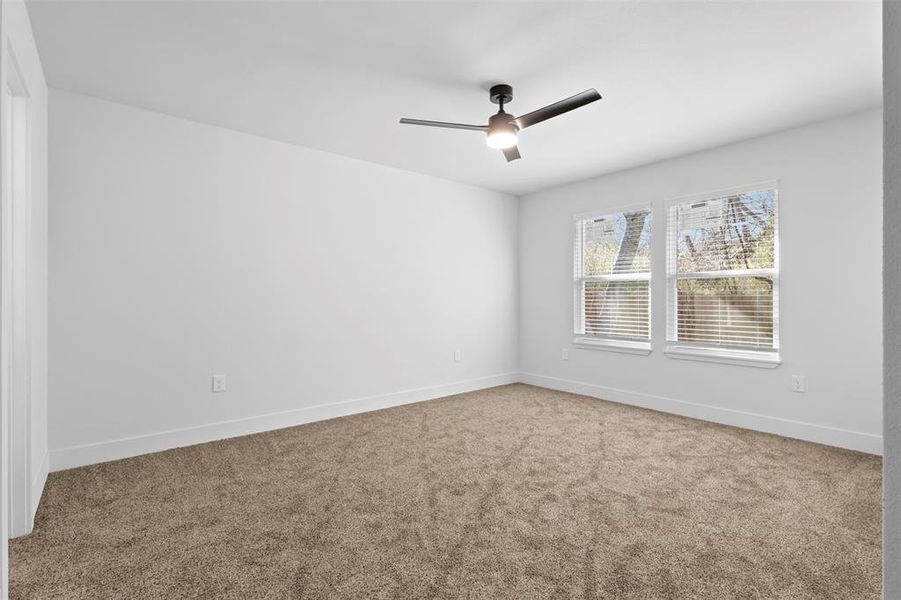 Carpeted spare room featuring ceiling fan