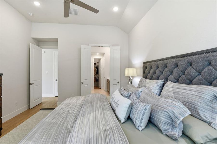 Vaulted ceiling bedroom featuring light wood-finish flooring, recessed lighting, and a ceiling fan Vaulted ceiling bedroom featuring light wood-finish flooring, recessed lighting, and a ceiling fan