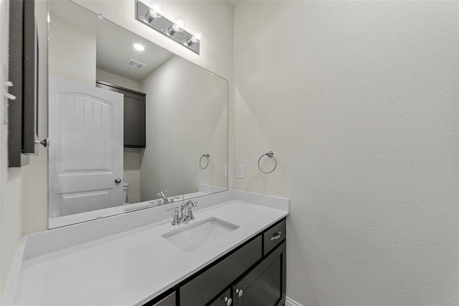 Bathroom with vanity, a textured wall, and recessed lighting Bathroom with vanity, a textured wall, and recessed lighting