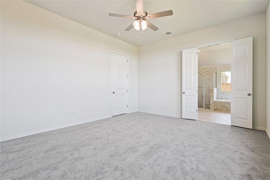 Carpeted empty room with ceiling fan