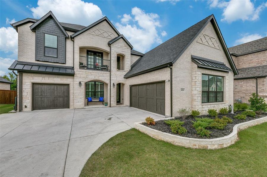 French provincial home featuring a 3 car garage, and balcony.