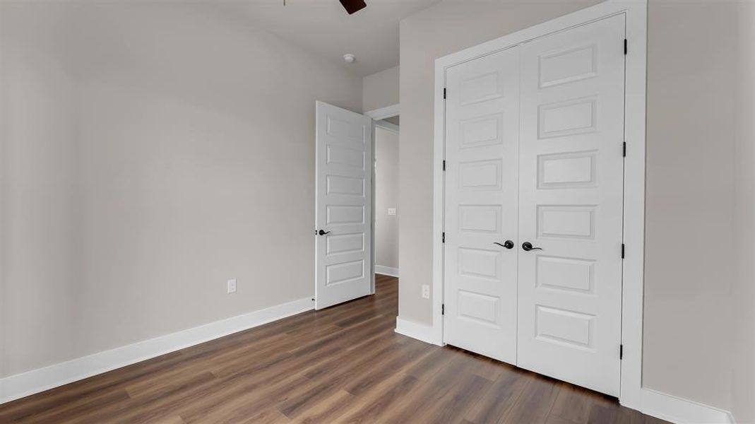 Rich wood-look flooring and crisp white trim define this versatile secondary bedroom space. Rich wood-look flooring and crisp white trim define this versatile secondary bedroom space.