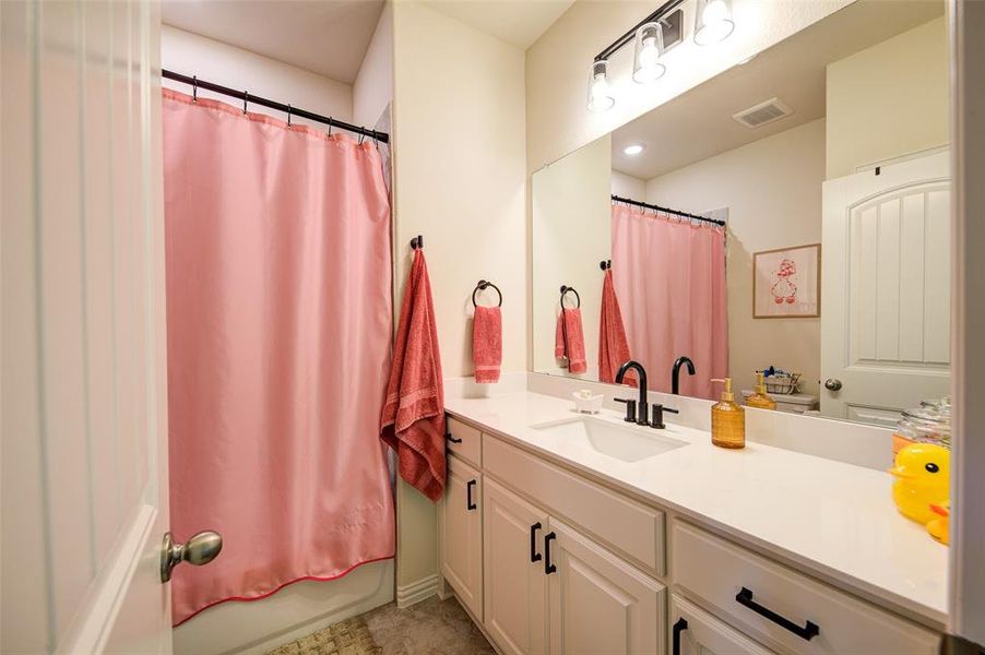 Bathroom with vanity and shower / tub combo with curtain