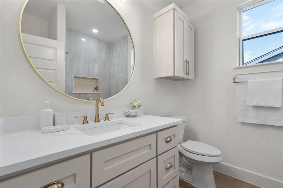 Full bath featuring vanity, tiled shower, and dark wood-type flooring Full bath featuring vanity, tiled shower, and dark wood-type flooring
