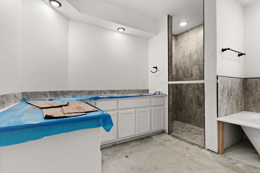 Bathroom with tiled shower, a freestanding tub, unfinished concrete flooring, and vanity Bathroom with tiled shower, a freestanding tub, unfinished concrete flooring, and vanity