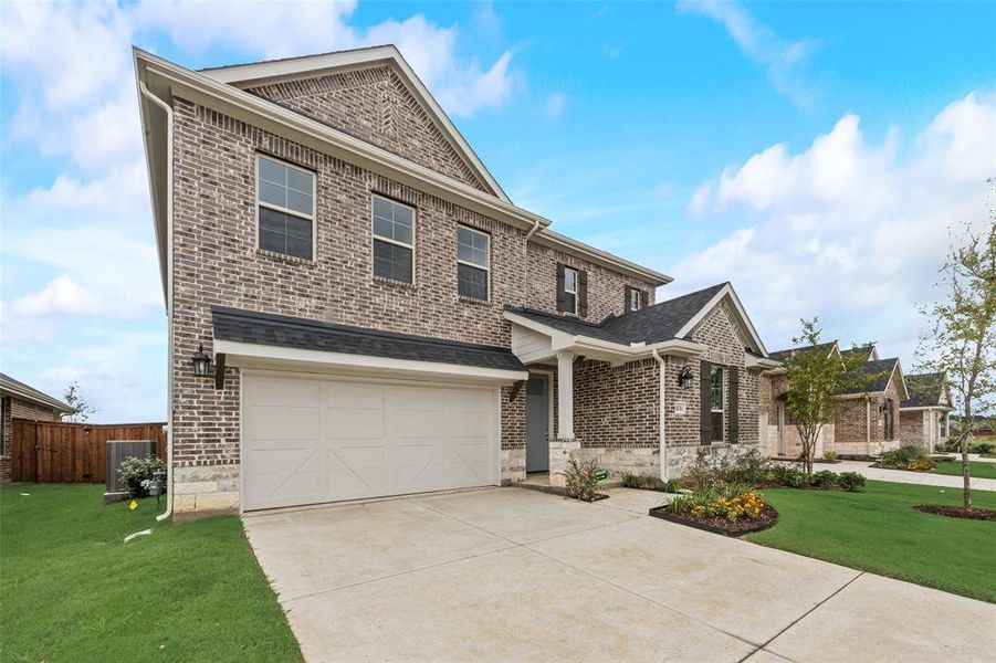 Front exterior of a new home in Spiritas Ranch, Little Elm, TX, highlighting curb appeal (Image 16). Front exterior of a new home in Spiritas Ranch, Little Elm, TX, highlighting curb appeal (Image 16).