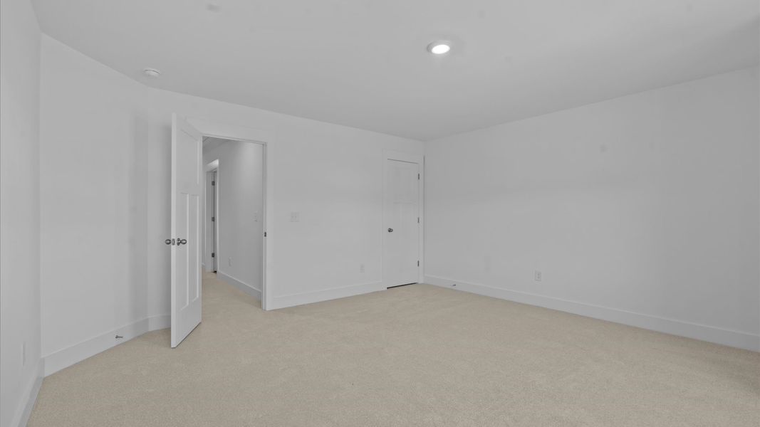 Superior comfort in a secondary bedroom with plush carpet and an oversized walk-in closet