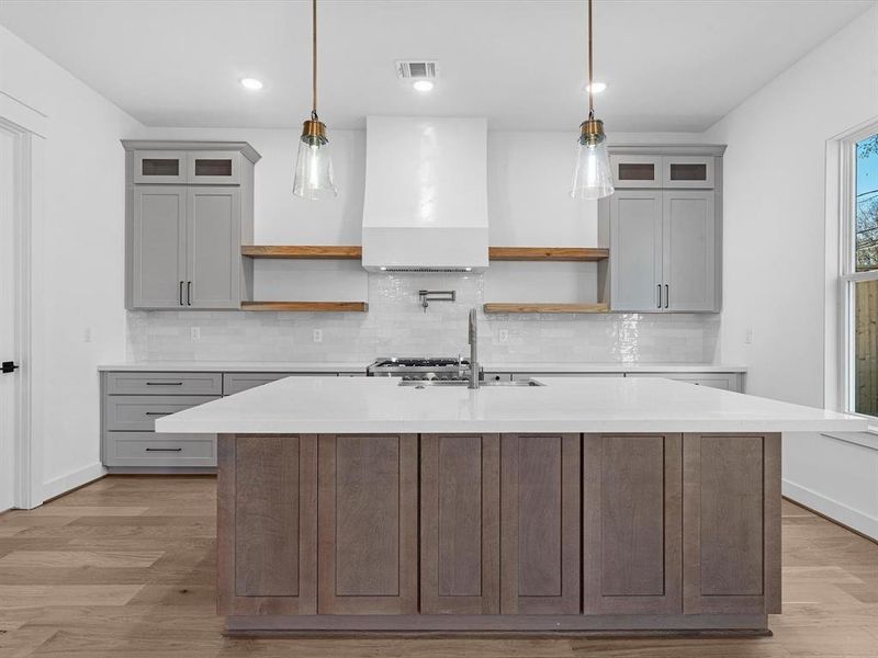 Plastered vent hood, champagne bronze faucet and potfiller. Accented floating shelves and spice drawers