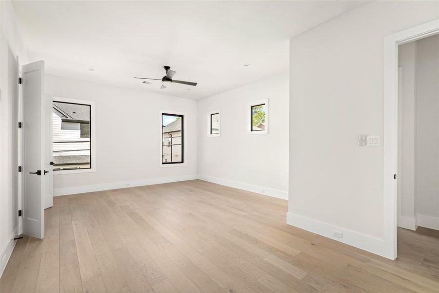 Spacious secondary bedroom with multiple windows allowing abundant natural light. Features clean lines, hardwood flooring, and ample wall space ideal for personalized design or furnishings. Spacious secondary bedroom with multiple windows allowing abundant natural light. Features clean lines, hardwood flooring, and ample wall space ideal for personalized design or furnishings.