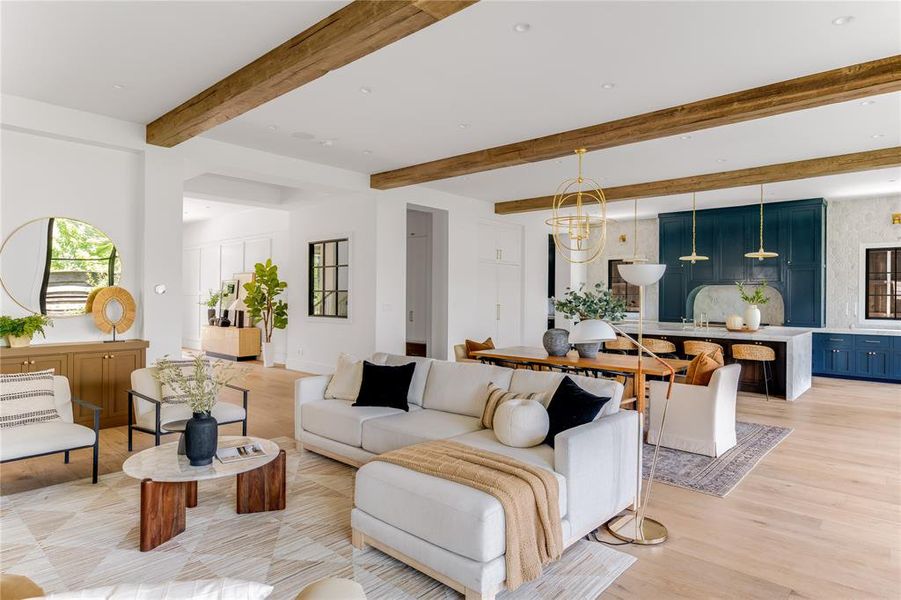 Living room with light hardwood / wood-style flooring and beam ceiling