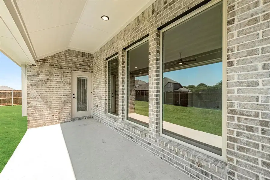 Covered patio featuring a concrete slab and brick exterior Covered patio featuring a concrete slab and brick exterior