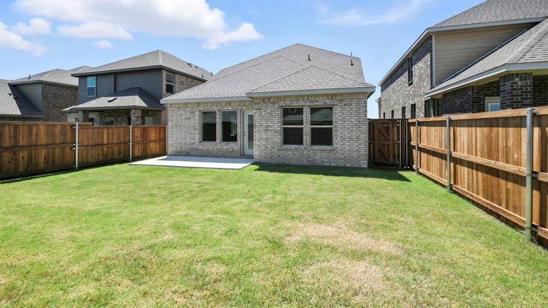 Back of house featuring a patio area, brick siding, a fenced backyard, a gate, and a shingled roof