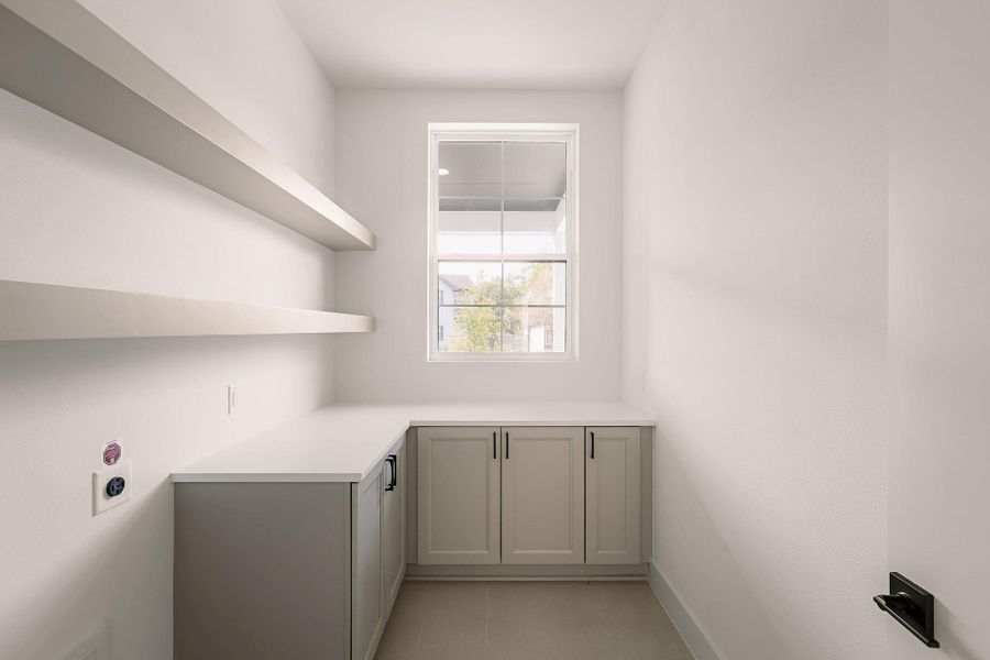 Washroom featuring cabinet space and hookup for an electric dryer Washroom featuring cabinet space and hookup for an electric dryer