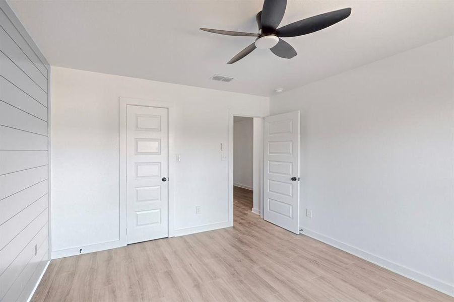 Unfurnished bedroom with a closet, light hardwood / wood-style floors, and ceiling fan