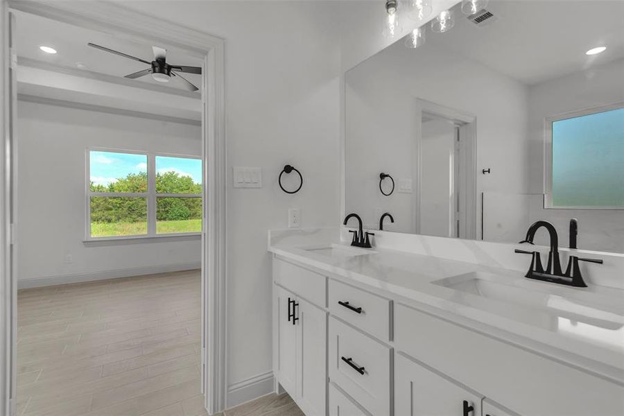 Full bathroom with double vanity, a ceiling fan, recessed lighting, and wood finished floors Full bathroom with double vanity, a ceiling fan, recessed lighting, and wood finished floors