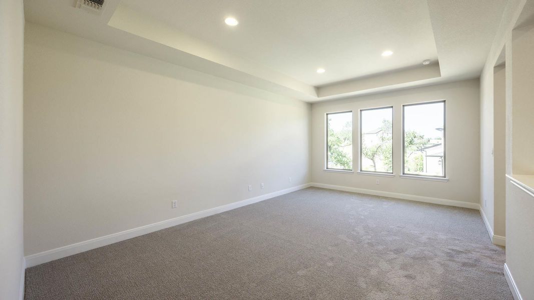 Carpeted spare room with a tray ceiling and recessed lighting Carpeted spare room with a tray ceiling and recessed lighting