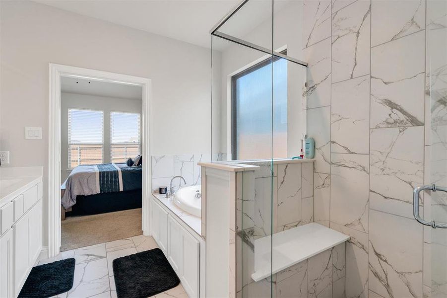 Contemporary bathroom featuring a spacious walk-in shower with a built-in bench, marble-finish tile, and a glass enclosure